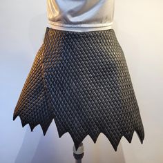 a woman's white top and black skirt on display