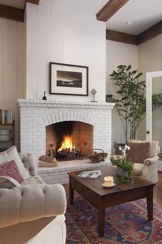 a living room filled with furniture and a fire place in the middle of a room