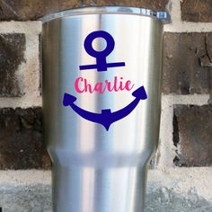 a stainless steel tumbler with an anchor and the word charlie painted on it's side