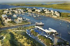 an aerial view of a marina with many boats and houses on the water in the background