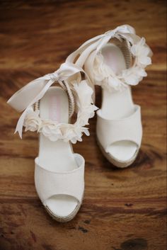 a pair of white shoes on top of a wooden floor