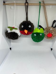 three stuffed animals hanging from hooks on a wall