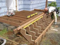 a man is working on the side of a house with wooden steps and ladders