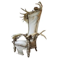 an old chair with antlers on the back and arm rests in front of a white background