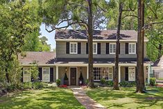 a house that is surrounded by trees and grass