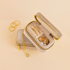 an open jewelry box with two wedding rings in it next to some gold ring boxes