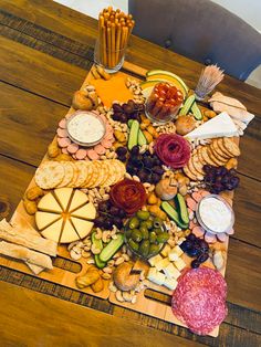 a wooden table topped with lots of different types of cheese and crackers on top of it