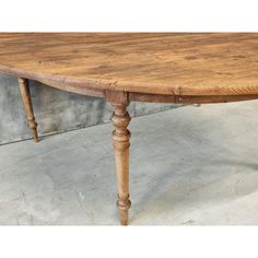 an old wooden table sitting on top of a cement floor