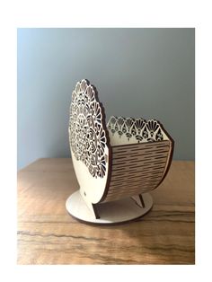 a white and brown vase sitting on top of a wooden table