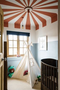 a child's room with a teepee tent in the corner