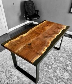 a wooden table sitting on top of a carpeted floor next to an office chair