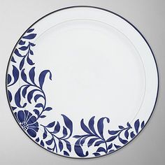 a blue and white plate with floral designs on the rim, against a gray background