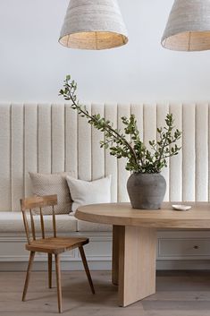 a wooden table sitting under two lamps next to a white couch