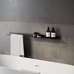 a bathroom with a bathtub and two bottles on the shelf next to each other