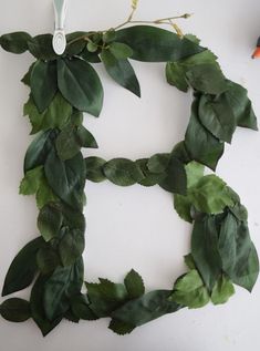 the letter h is made out of leaves and scissors on a white surface with other items around it