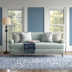 a living room with blue walls and white furniture