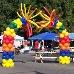 an arch made out of balloons in the middle of a street