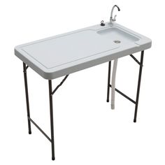 a white sink sitting under a faucet next to a metal stand with legs