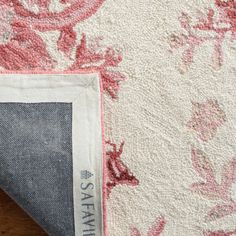 an area rug with pink and white flowers on it