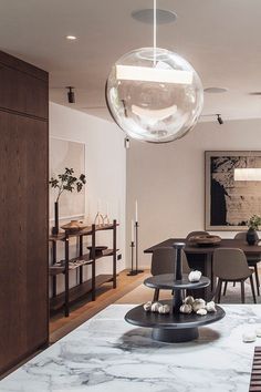 a modern dining room with marble table and chairs