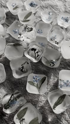 many glass dishes with blue flowers on them are scattered across a tableclothed surface