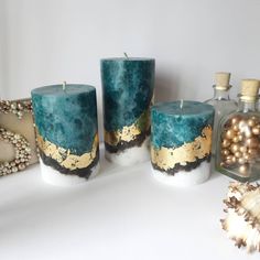 three teal candles sitting on top of a table