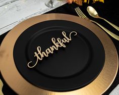 a black and gold plate with the word thank written on it