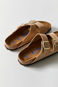 The legendary two-strap design from Birkenstock. The Arizona combines iconic style with signature comfort, featuring an additional soft layer in the anatomically formed footbed with integrated latex foam cushion. Nubuck leather upper with individually adjustable metal pin buckles. Content + Care Leather, cork, EVA Spot clean Imported Size + Fit True to size Medium/Narrow width | Birkenstock Arizona Soft Footbed Leather Sandal in Sandcastle Nubuck, Women's at Urban Outfitters Arizona Birkenstock Outfit, Birkenstock Arizona Outfit, Leather Birkenstocks, Birkenstock Sandals Outfit, Shoe Goals, Sandal Design, Birkenstock Outfit, Birkenstock Sandals Arizona, Wardrobe Goals