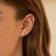 a close up of a person with ear piercings on their ears and one in the background