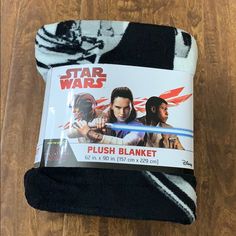 star wars plush blanket on wooden floor with black and white striped design, featuring two men's characters