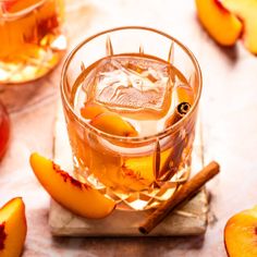 a glass filled with liquid next to sliced peaches