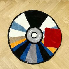 a colorful rug on the floor with a circular design in red, white, blue, and yellow