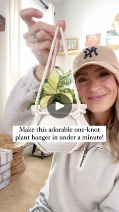 a woman is holding up a plant hanging from a string with the caption make this adorable one - knot plant hanger in under a minute