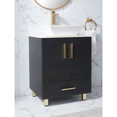 a white sink sitting under a mirror next to a black cabinet with gold trimmings