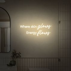 there is a neon sign that says where skin glows energy flows on the wall