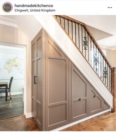 an open staircase leading up to a dining room table and chairs in the background with wooden flooring