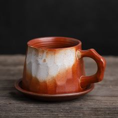 a brown and white cup sitting on top of a wooden table