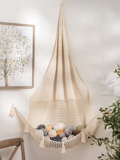 a hammock hanging from the ceiling with balls in it