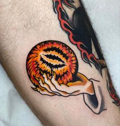 a man's arm with a tattoo on it that has flames coming out of it