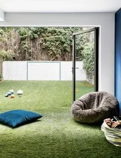 a room with green grass and blue walls, including a bean bag chair on the floor