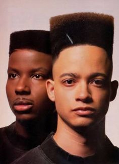 two men with hair combs on their heads and one is looking at the camera