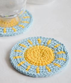 two crocheted coasters sitting on top of a table