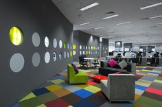 an office with brightly colored carpet and furniture