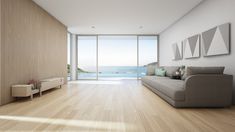 an empty living room with wood floors and large sliding glass doors leading to the ocean