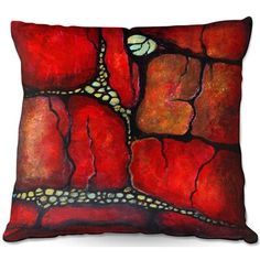 a red pillow with an image of a lizard crawling on the ground in front of it