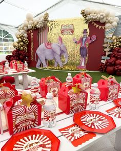 a table topped with lots of red and white plates covered in candy canes next to an elephant