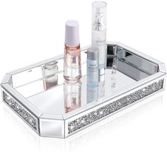 a silver tray with cosmetics and perfume bottles on it