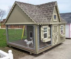 a small dog house with a fence around it and a white dog in the doorway