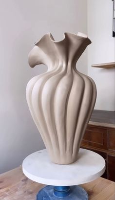 a large white vase sitting on top of a table