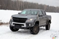 a truck is parked in the snow near some trees